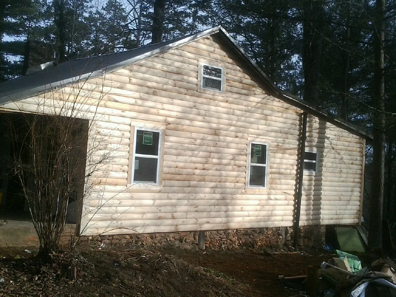 New log siding and dark metal roofing on a gable end in Gardena
