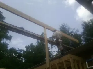 Carpenter setting a ridge beam over a new addition frame — Ice Dam Removal by Roofing Brothers in Gardena