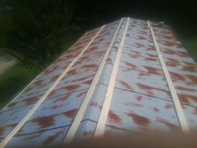 Rusted metal roof panels with new wood purlins before replacement — Storm Damage Roof Repair in Gardena by Roofing Brothers