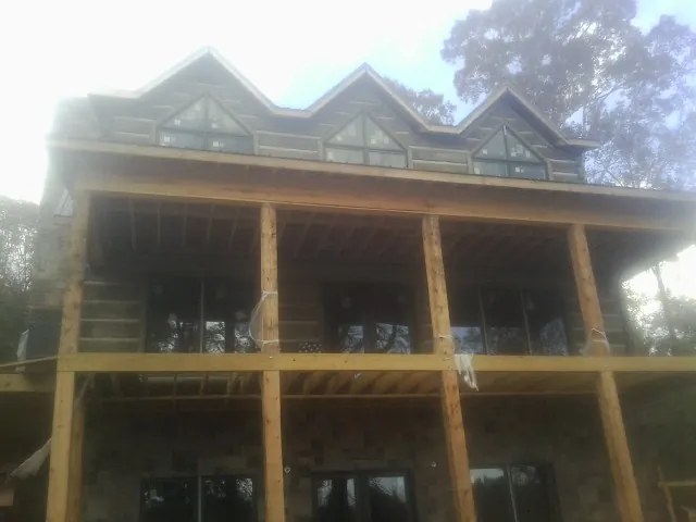 Dormers and porch framing on a large log home under construction — Roof Coating work by our crew in Gardena
